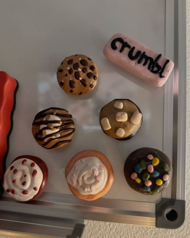 Crumbl-style clay cookie magnets with drizzles, marshmallows and sprinkles on a whiteboard