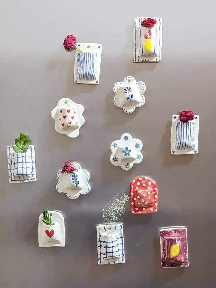 Mini clay vase pocket magnets holding real dried flowers, painted with blue linework and gingham