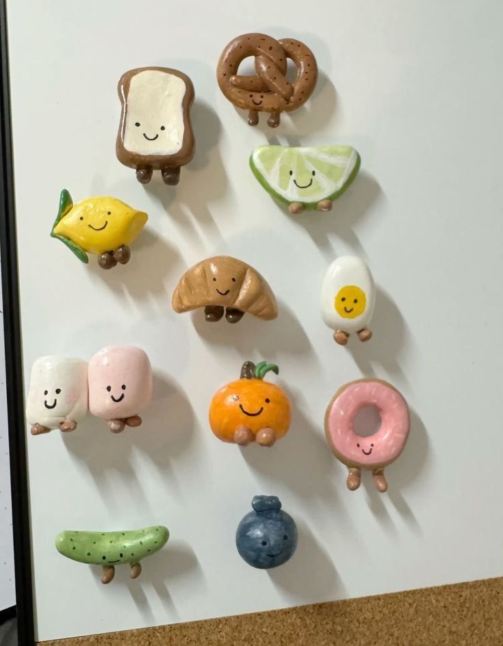 Smiling clay character magnets shaped like a pretzel, toast, croissant, donut and boiled egg with faces and legs