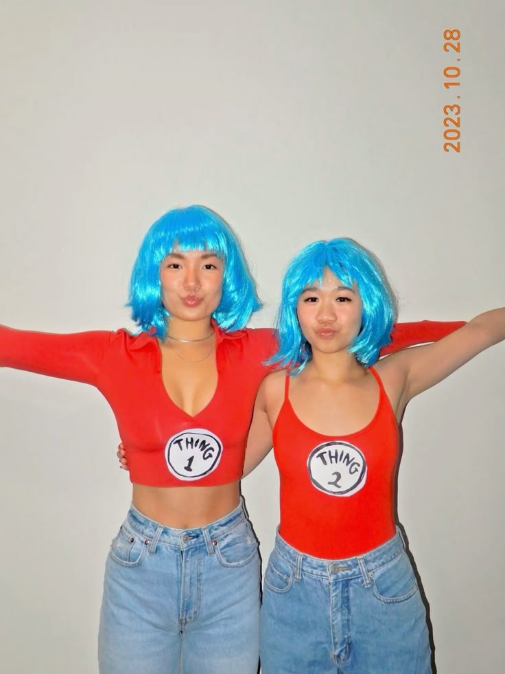Two friends in blue wigs and red tops with Thing 1 and Thing 2 circle logos