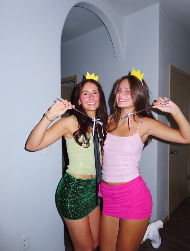 Two people in sparkly green and pink sequin minis with small gold crowns dressed as Cosmo and Wanda from The Fairly OddParents
