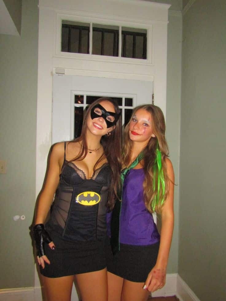 Two friends dressed as Batman in a bat-logo bustier and the Joker in purple and green with face paint