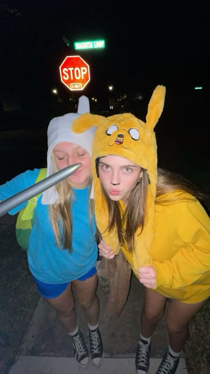 Two friends in Finn and Jake hats from Adventure Time, in blue and yellow tops