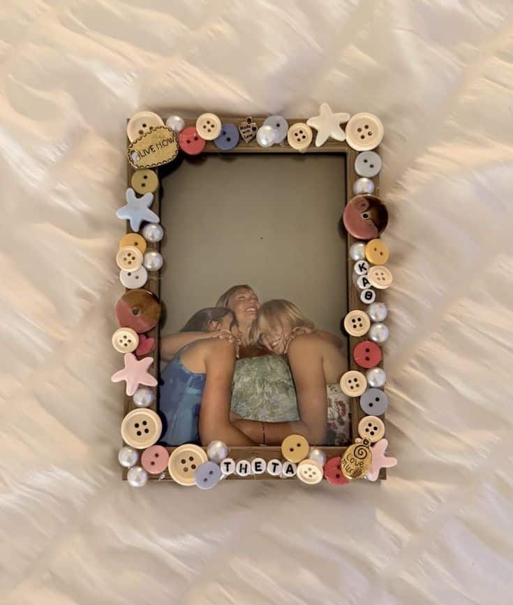 Photo frame decorated with colourful buttons, pearls, charms and letter beads