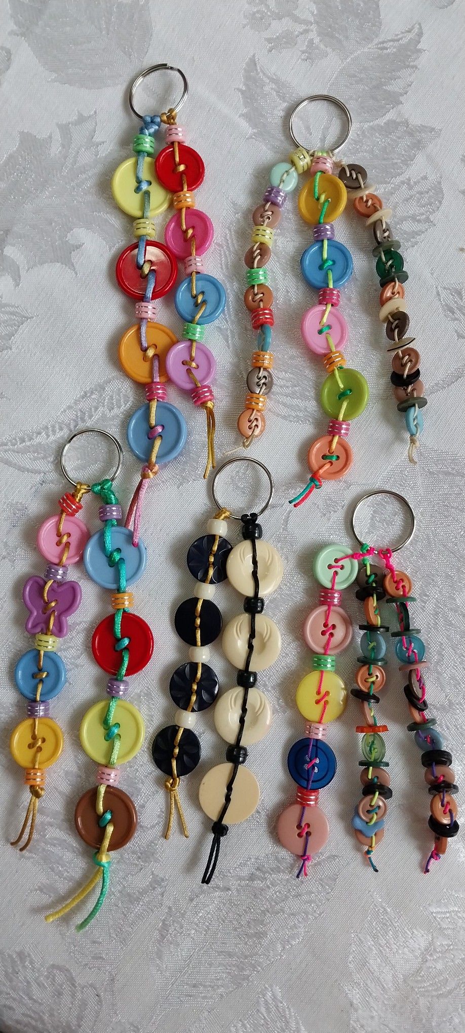 Handmade keyrings made from colourful buttons threaded on cord with beads