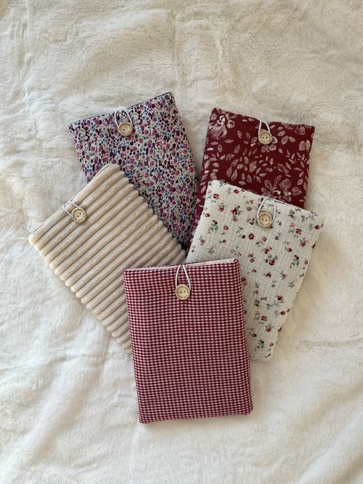 Padded fabric book sleeves in floral, gingham and cord with button closures