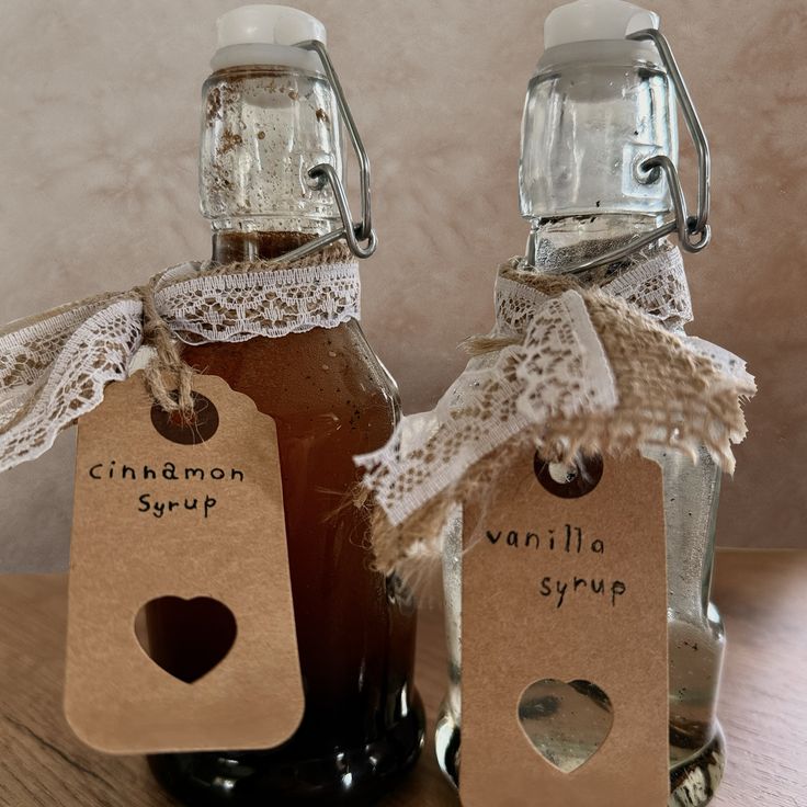 Swing-top bottles of homemade cinnamon and vanilla syrup tied with lace, hessian and kraft heart tags