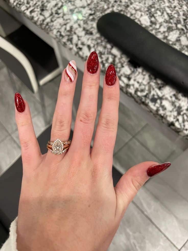 Christmas nails in red glitter with a candy cane striped accent nail