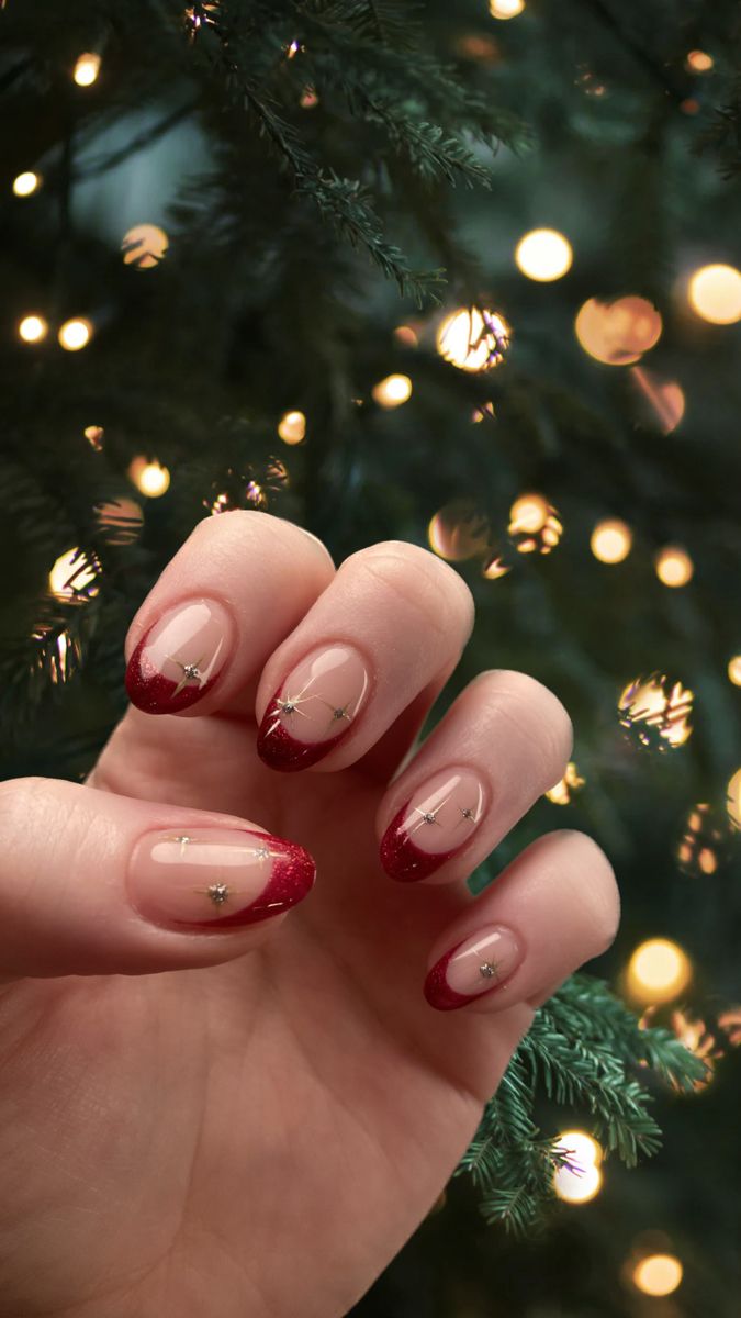 Burgundy glitter French tip Christmas nails with tiny gold stars