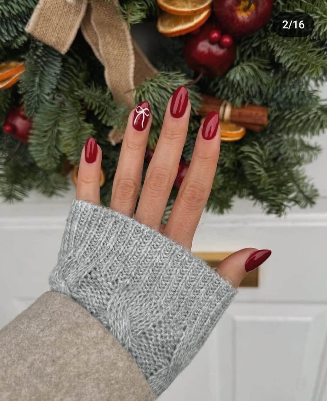 Deep red Christmas nails with a small white bow accent