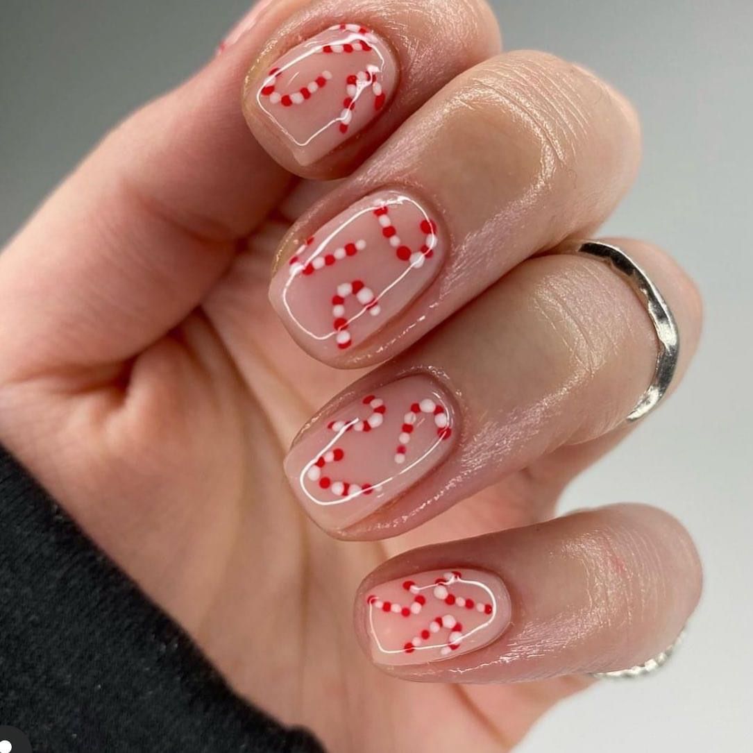 Short nude Christmas nails with red and white dotted candy canes