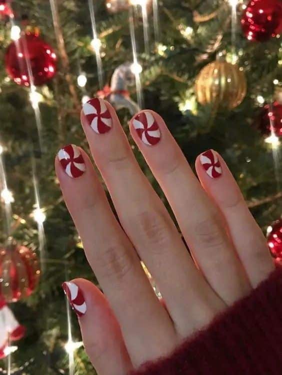 Short Christmas nails with red and white peppermint swirls
