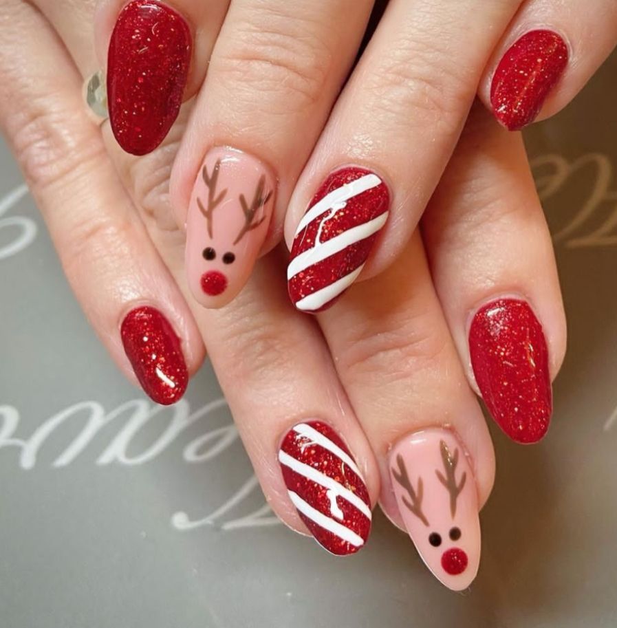 Red glitter Christmas nails with reindeer and candy cane stripe accents
