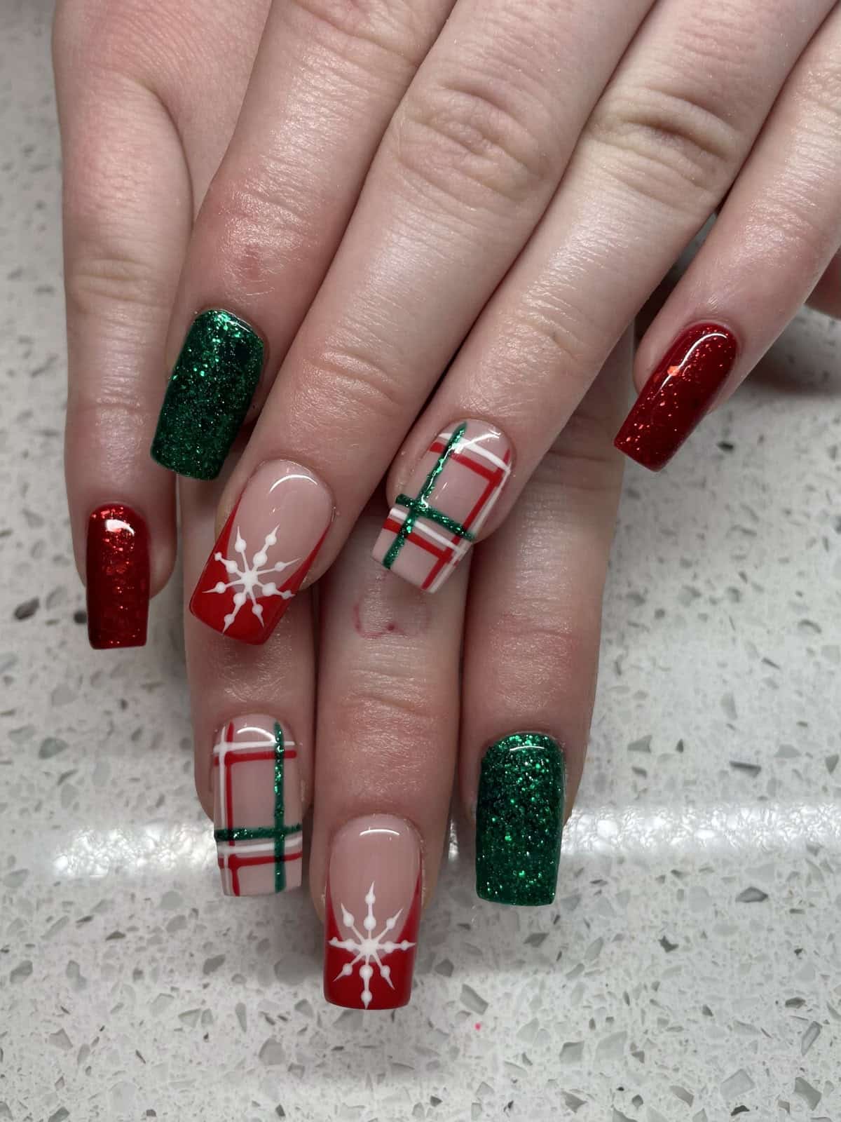 Square Christmas nails with red and green glitter, plaid and a white snowflake