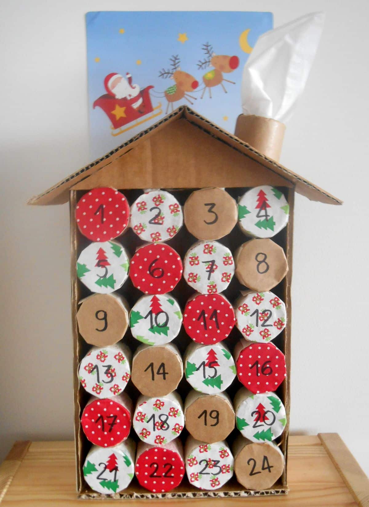 Toilet roll advent calendar shaped like a house with patterned paper ends numbered 1 to 24