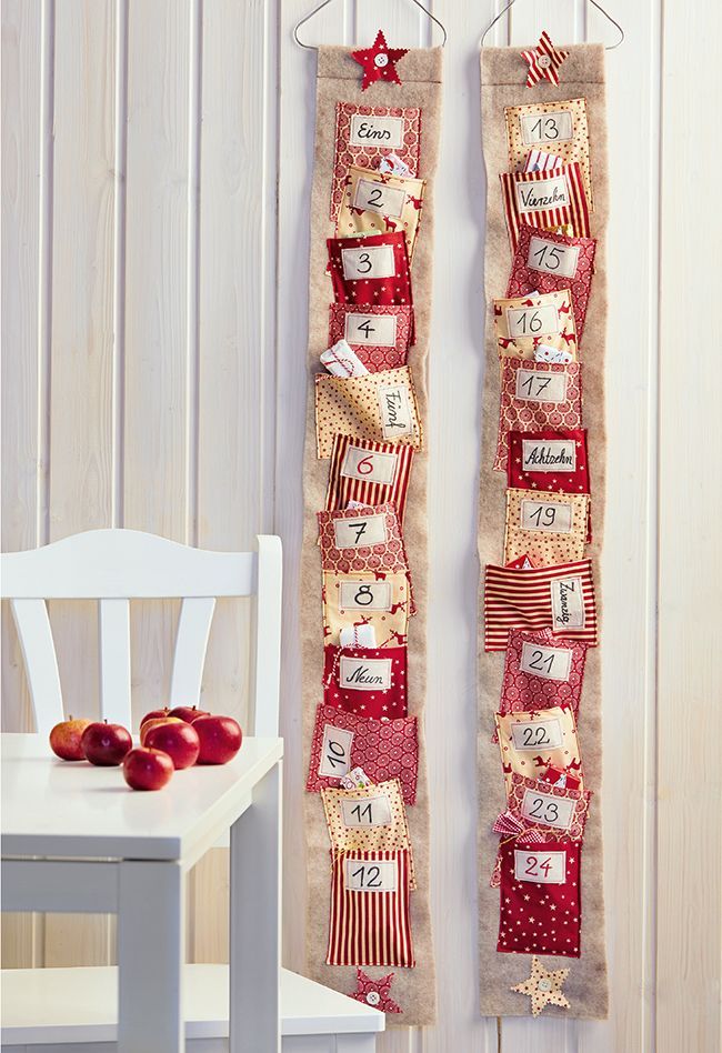 Two long felt strip advent calendars with red and cream patchwork pockets and handwritten numbers