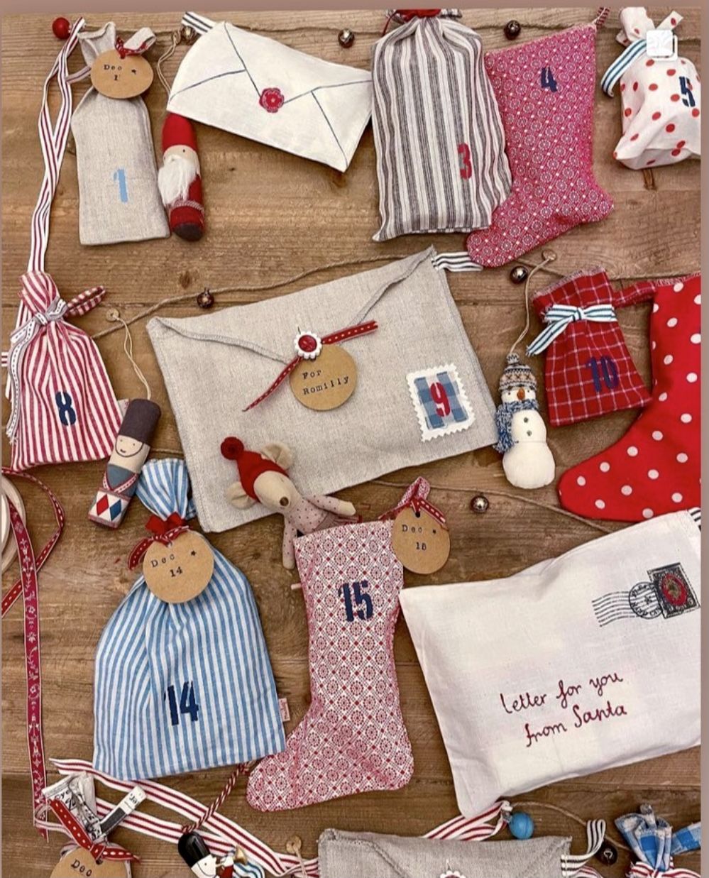 Linen envelopes, mini stockings and striped drawstring bags laid out as a fabric advent calendar