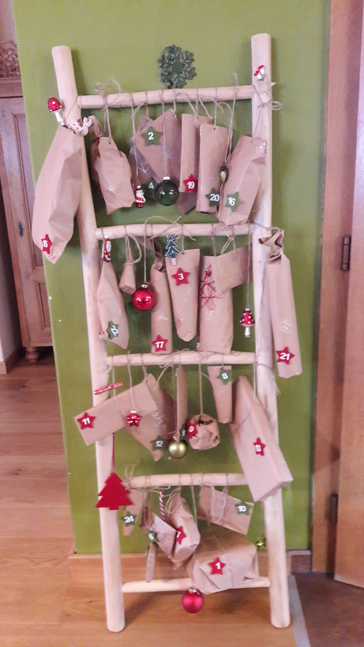 Wooden ladder advent calendar with kraft paper parcels, felt star numbers and glass baubles