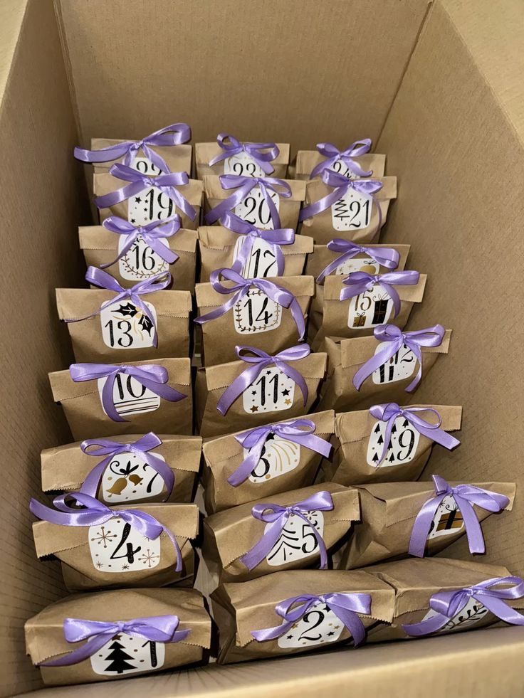 Rows of kraft paper bags tied with lilac satin ribbon and numbered tags inside a box