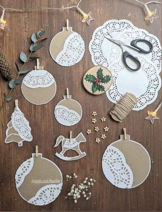 Cardboard bauble and rocking horse ornaments layered with white paper doilies and mini wooden pegs