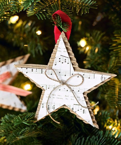Sheet music star ornament backed with corrugated cardboard and tied with twine hanging on a Christmas tree