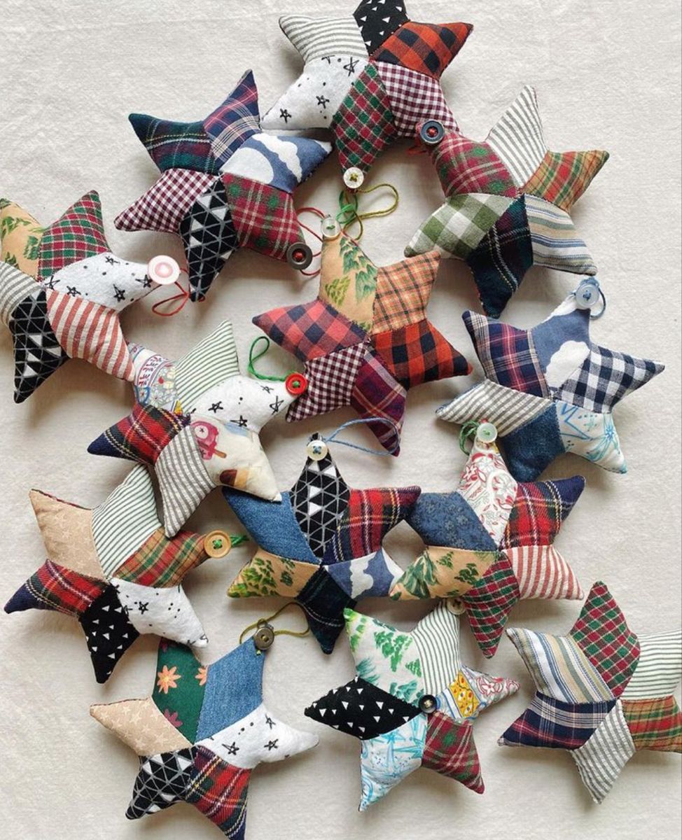 Collection of stuffed patchwork fabric star ornaments in plaid, ticking and novelty prints with button hangers