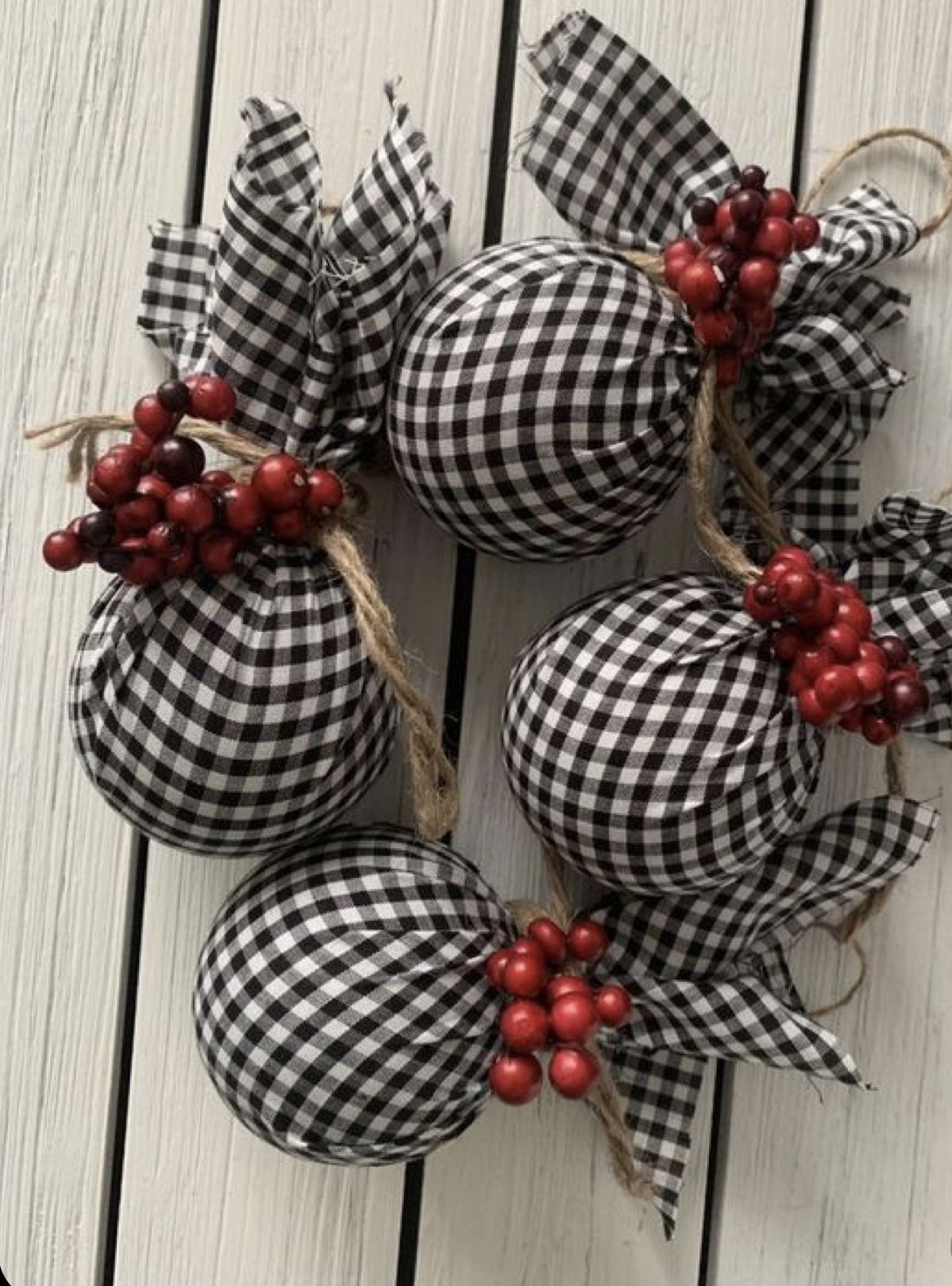 Black and white gingham fabric wrapped baubles tied with jute twine and red berry clusters