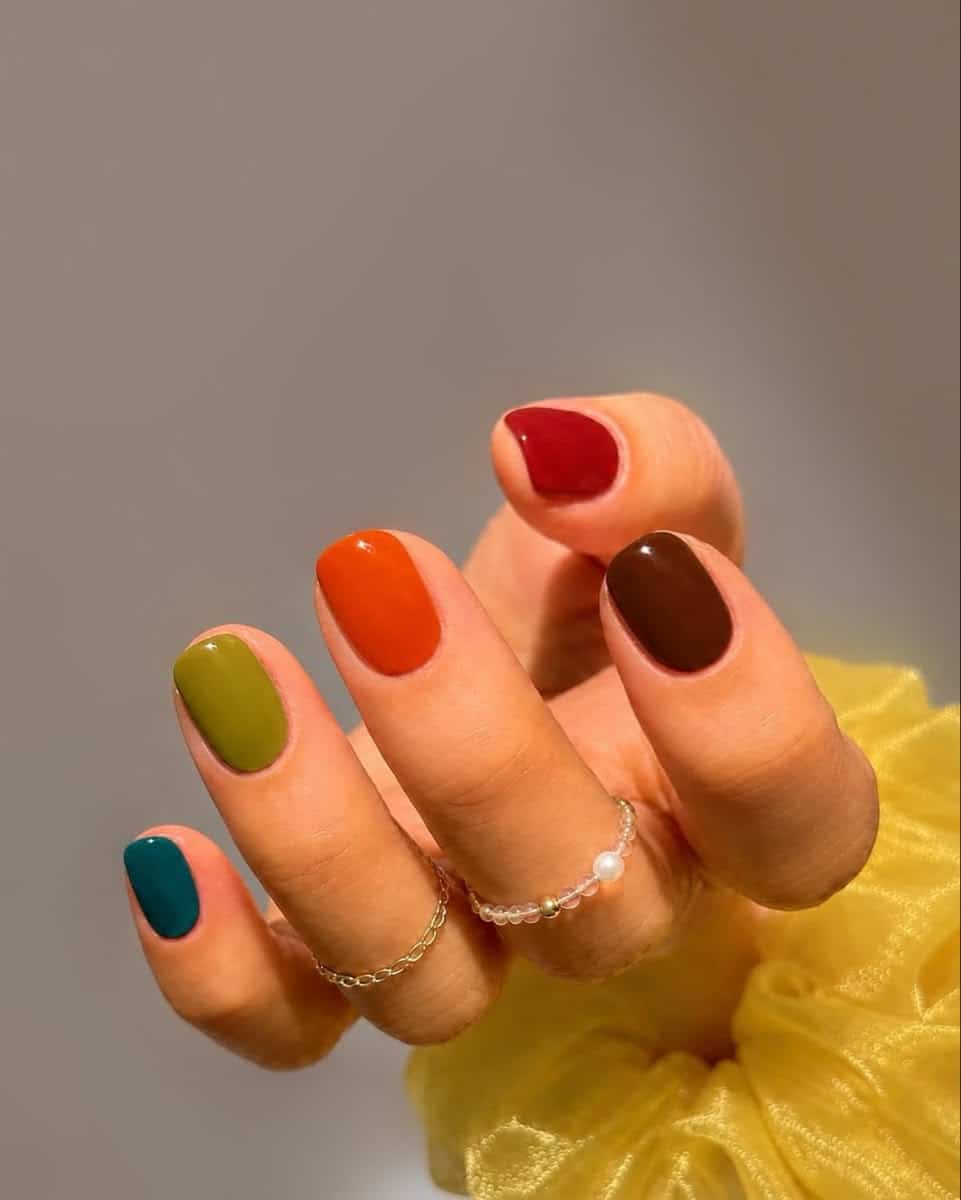 Short skittle manicure in teal, olive, burnt orange, chocolate brown and cranberry